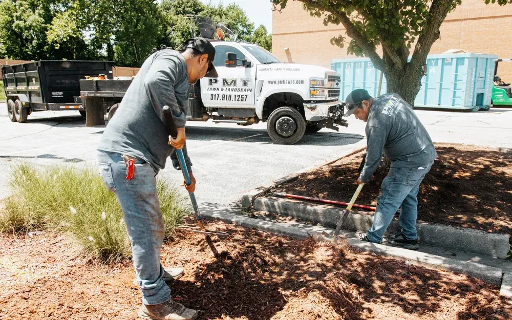 PMT Lawn & Landscape crew mulching landscape beds at a commercial property