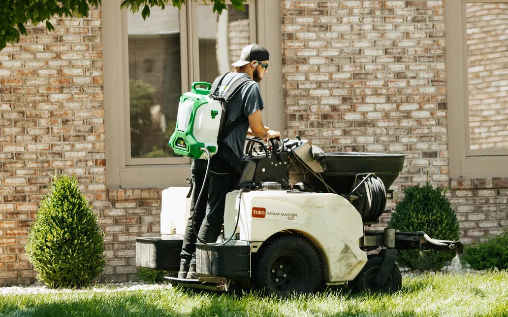 Technician applying lawn fertilizer and weed control on a lawn near Indianapolis, IN