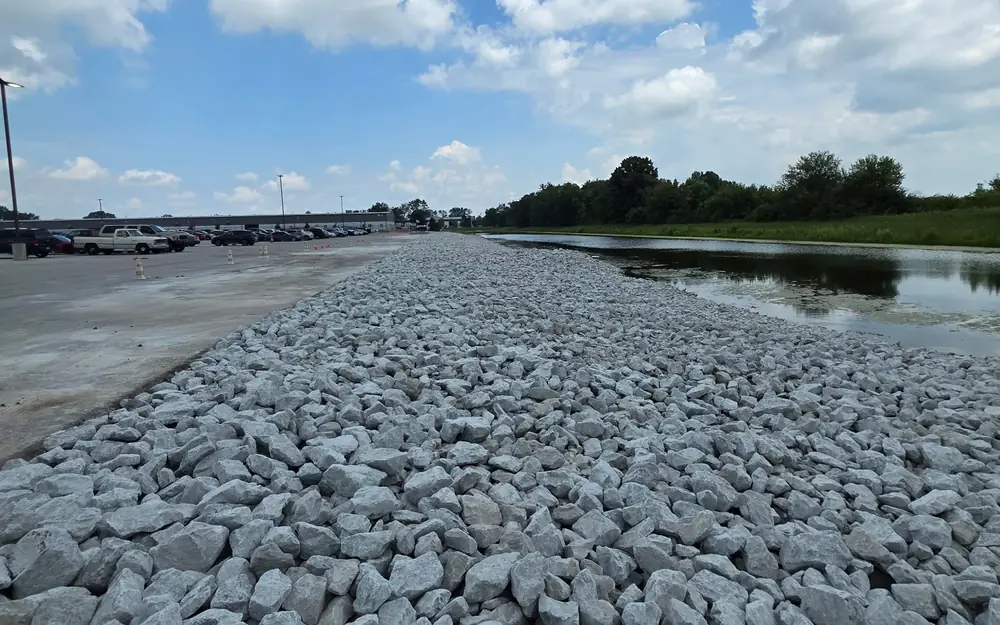 Commercial rip rap stone shoreline installed along a retention pond by PMT Lawn & Landscape