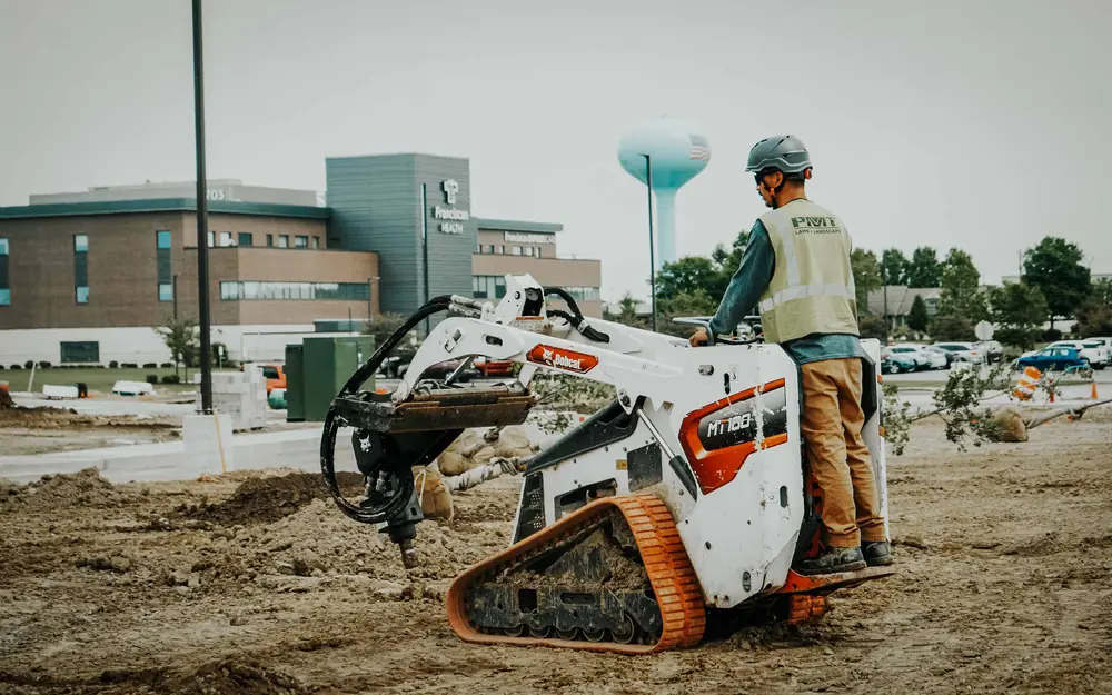Commercial landscape design site preparation with a compact track loader at a medical office