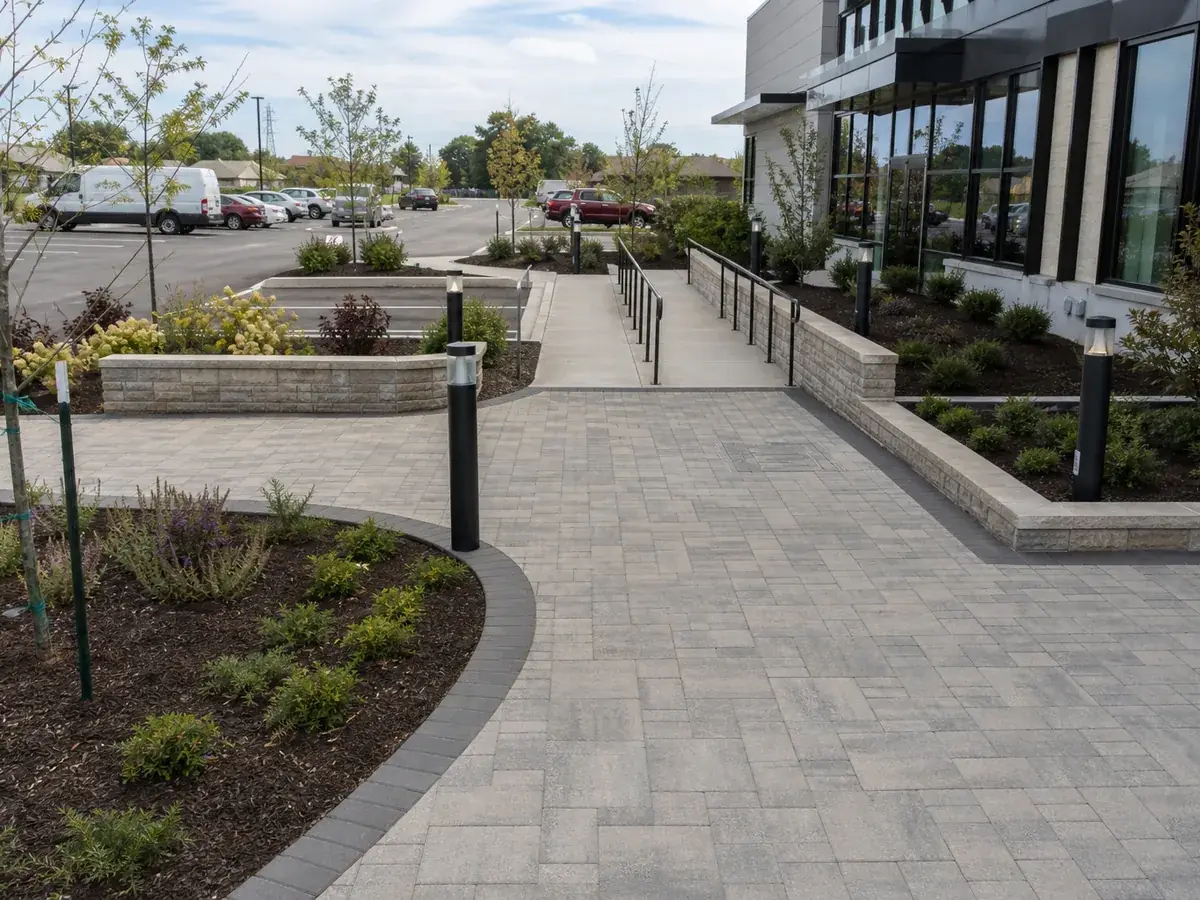 Finished paver entry plaza with seating walls and bollard lighting at an Indianapolis, IN business