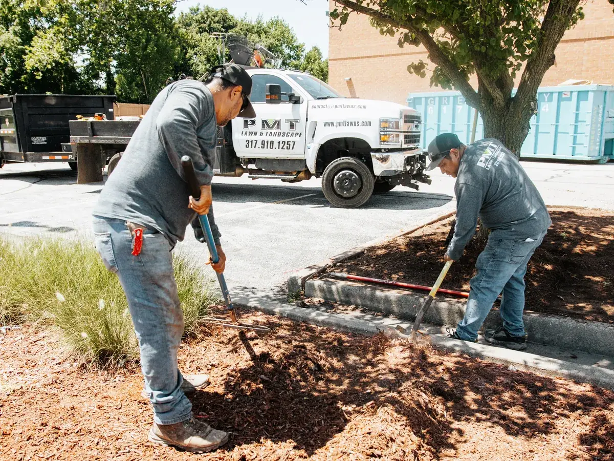 PMT Lawn & Landscape crew mulching landscape beds at a commercial property in Indianapolis, IN