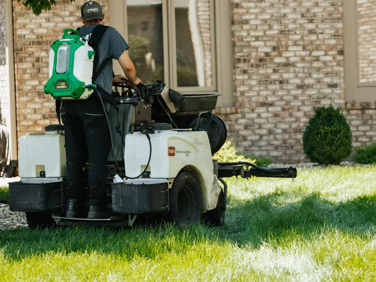 PMT Lawn & Landscape technician applying a full lawn treatment on a residential lawn in Indianapolis, IN