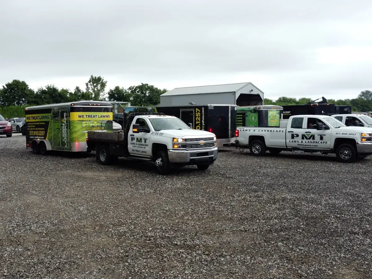 PMT Lawn & Landscape trucks and equipment trailers lined up at the company yard near Indianapolis, IN