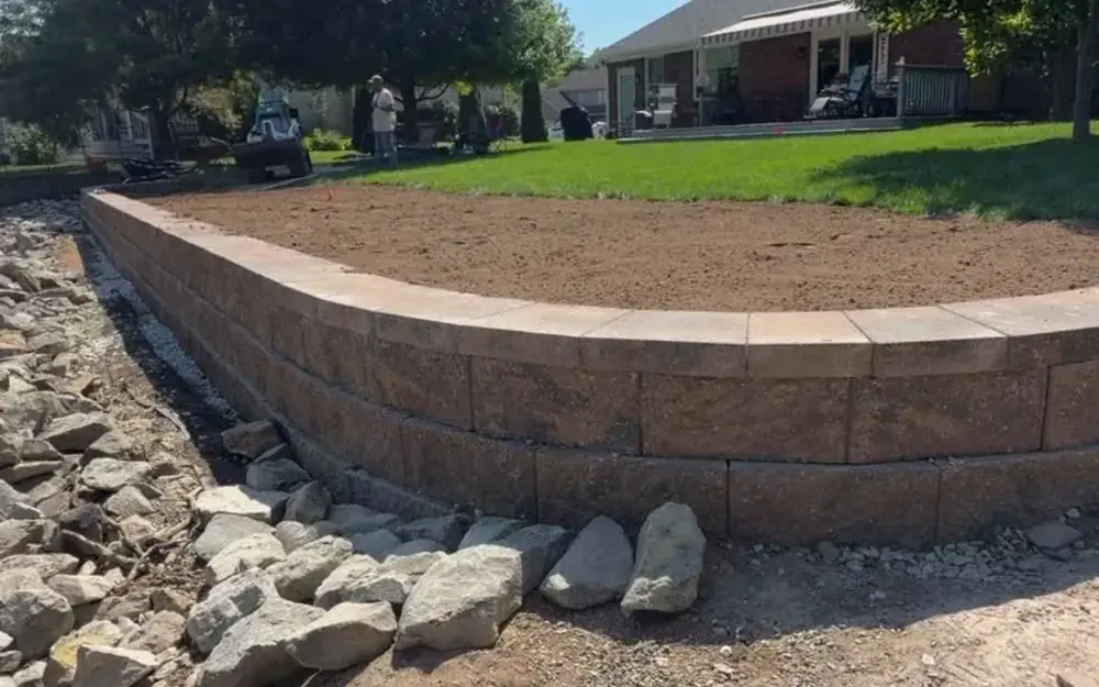 Curved segmental block retaining wall built on a backyard slope in Indianapolis, IN